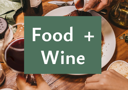 A cozy dinner scene with people sharing food as wine is poured, overlaid with the text &ldquo;Food + Wine&rdquo;.