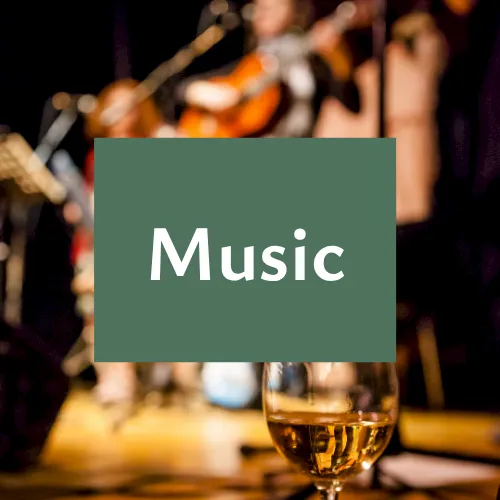 A blurred live music scene with instruments in the background, a champagne flute in front, and the word &ldquo;Music&rdquo; displayed.