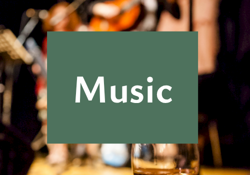 A blurred live band plays in the background with a glass in front and the centered text &ldquo;Music&rdquo; displayed.
